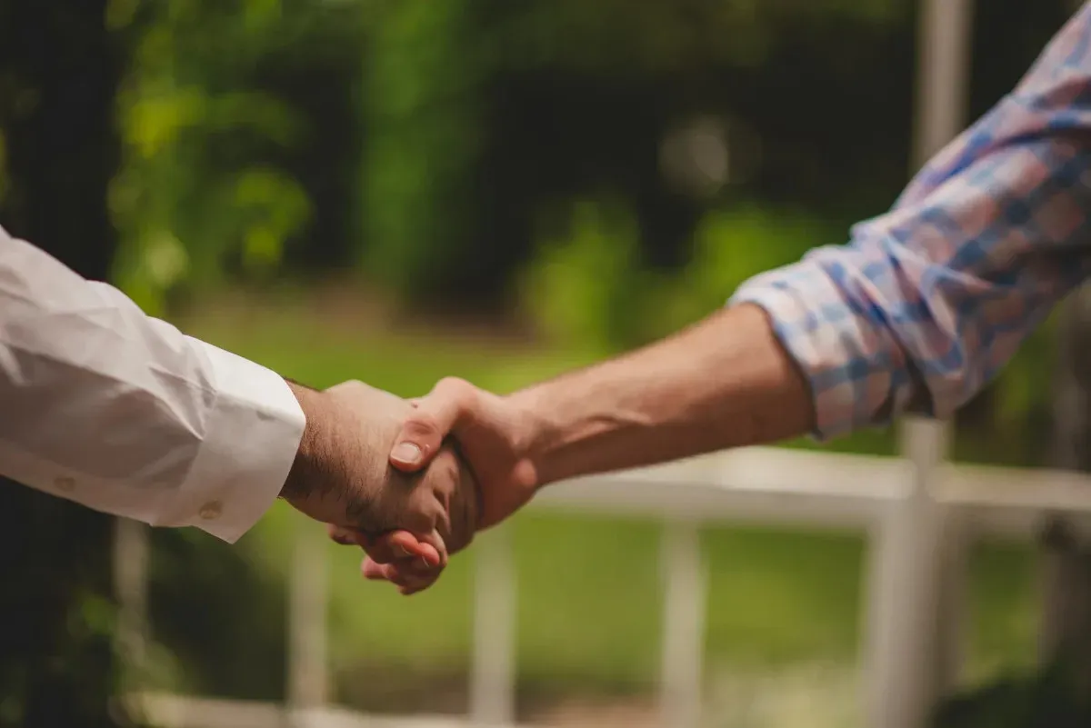 Ruce držící se v gestu spolupráce a partnerství