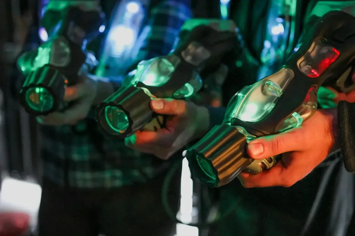 Skupina lidí hrající laser game v tmavé aréně