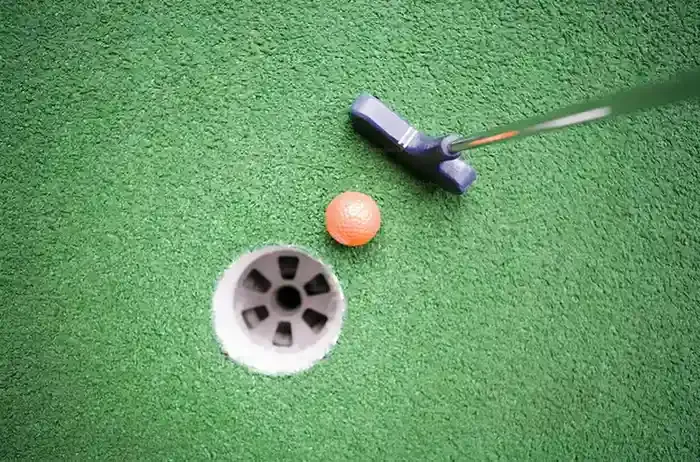 Rodina hrající minigolf na venkovním hřišti